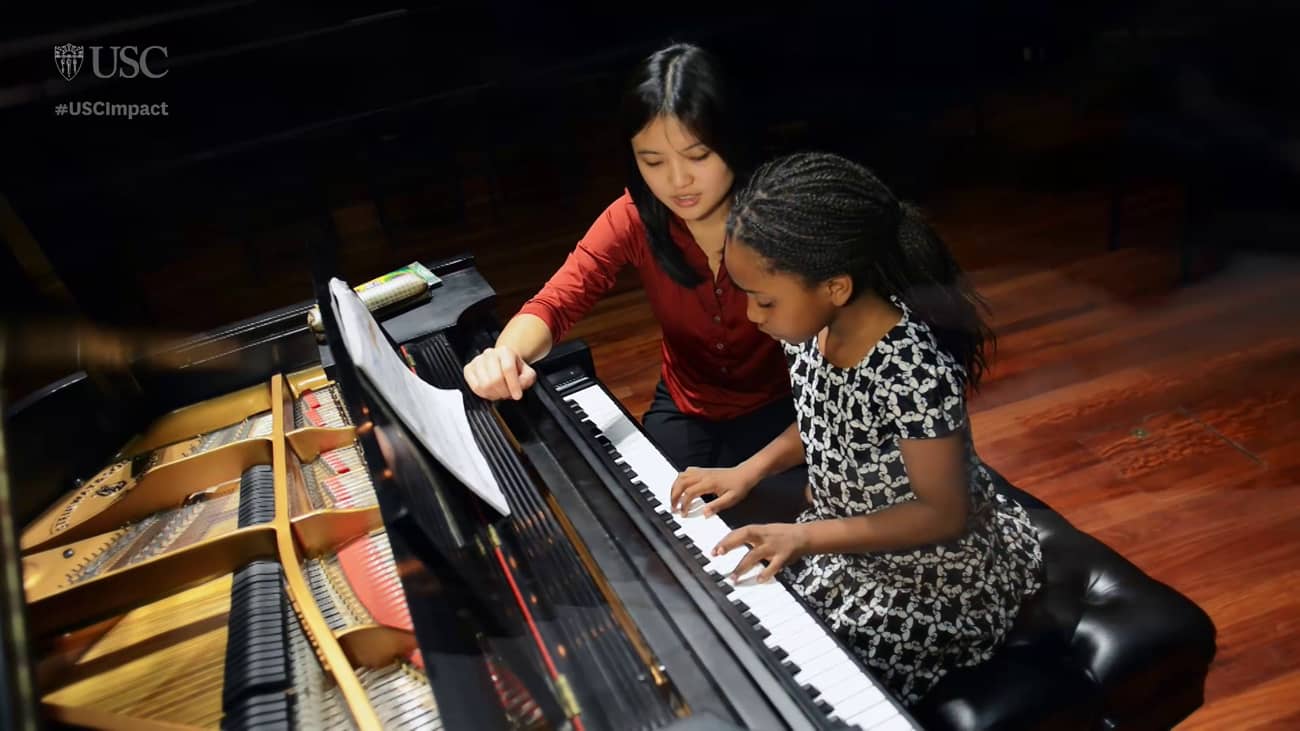USC student Ashley Hoe gives a child a piano lesson